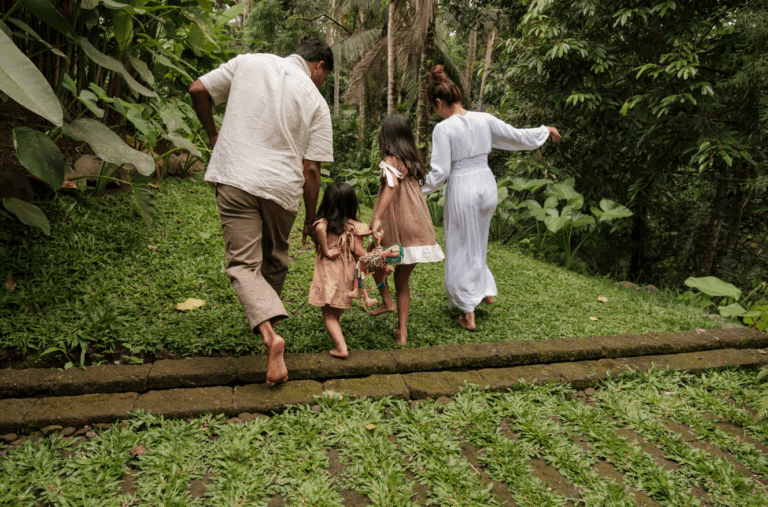 Multi-generational family walking barefoot through lush greenery, symbolizing legacy stewardship and long-term real estate vision