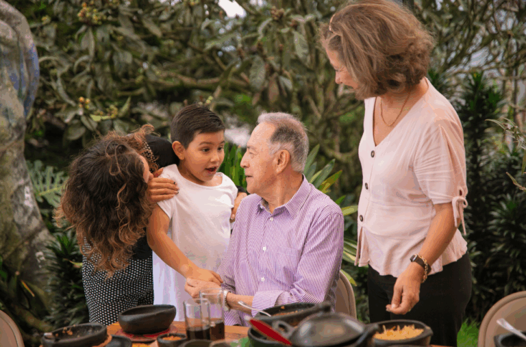 Three generations of a family gathered around an outdoor table, symbolizing multi-generational wealth planning through real estate investment