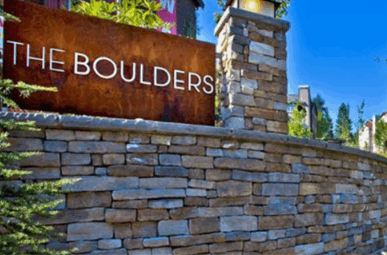 Stone entrance signage for The Boulders Condominiums, a multifamily residential community with upscale units and natural landscaping